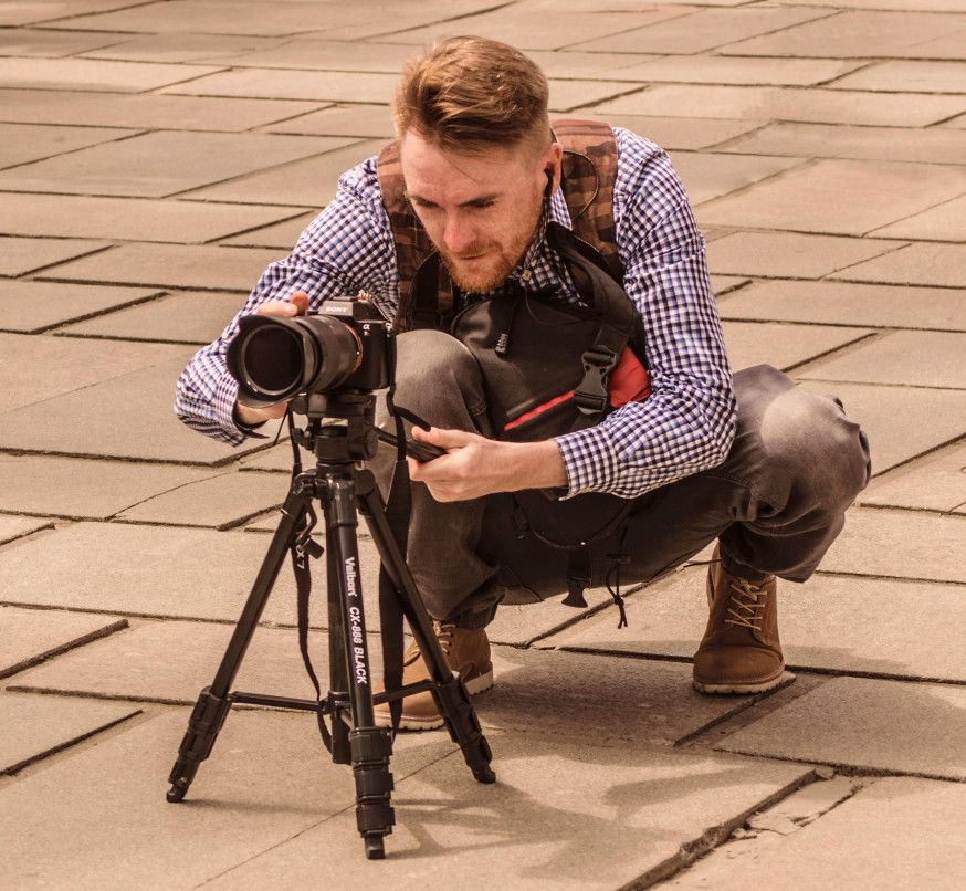 Afbeelding: een goede houding en goed door je knieën buigen in plaats van je rug helpt bij een goede ergonomie als fotograaf en voorkomt klachten