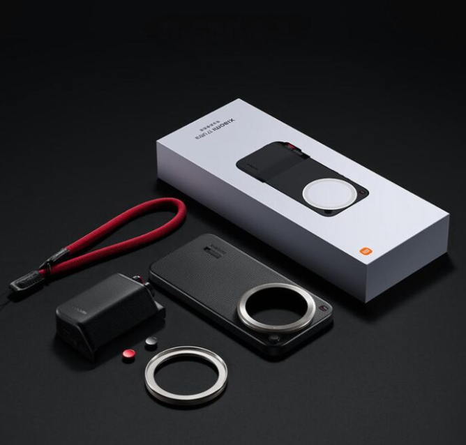 Afbeelding: De zwarte Xiaomi 17 Ultra Professional Photography Kit met zilveren details naast de witte verpakking, de nieuwe standaard voor modulaire smartphonefotografie