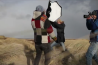 Met windkracht 10 een model fotograferen op het strand